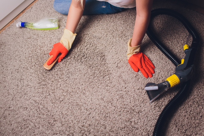 woman removing dirt on carpet